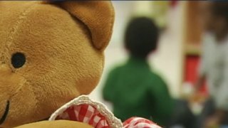 Child's stuffed bear with children in background