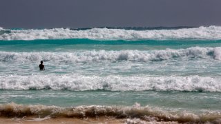 Bañista entre las olas de Cancún