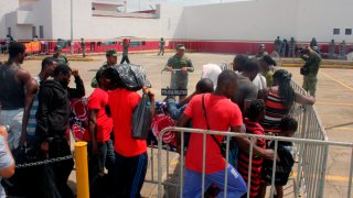 Migrantes esperan afuera de una estación en Chiapas