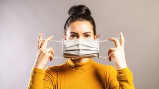 Mujer poniendose una mascarilla