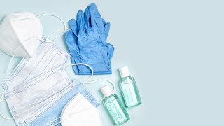 Foto de distintos tipos de mascarillas, guantes de latex y gel desinfectante para manos.