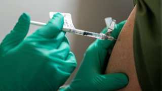 In this Dec. 16, 2020, file photo, a healthcare worker at the Portland Veterans Affairs Medical Center receives a COVID-19 vaccination in Portland, Oregon.