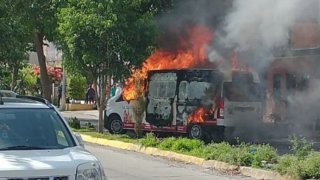 Fotografía de una camioneta de transporte de valores en llamas tras un asalto
