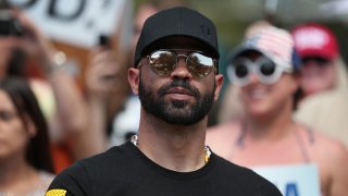 FILE - Enrique Tarrio, leader of the Proud Boys, stands outside of the Hyatt Regency where the Conservative Political Action Conference is being held on Feb. 27, 2021, in Orlando, Florida.