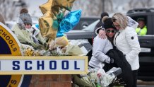 OXFORD, MICHIGAN - DECEMBER 01: People embrace as they visit a makeshift memorial outside of Oxford High School on December 01, 2021 in Oxford, Michigan. On Tuesday, three students were killed and eight injured when a gunman opened fire at the school. A fourth student died on Wednesday. The suspect, identified as 15-year-old Ethan Crumbley, has been charged as an adult with terrorism and first-degree murder.  (Photo by Scott Olson/Getty Images)