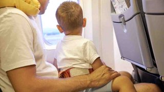 Archivo: padre con niño pequeña viaja en avión.