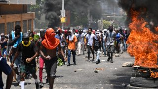 eople march as tires burn during a protest against insecurity, on August 7, 2023, near the Prime Minister's official house in Port-au-Prince, Haiti.