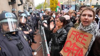 En esta imagen de archivo, policías antimotines hacen guardia mientras los manifestantes corean eslóganes en el exterior del campus de la Universidad de Columbia, el 18 de abril de 2024, en Nueva York.