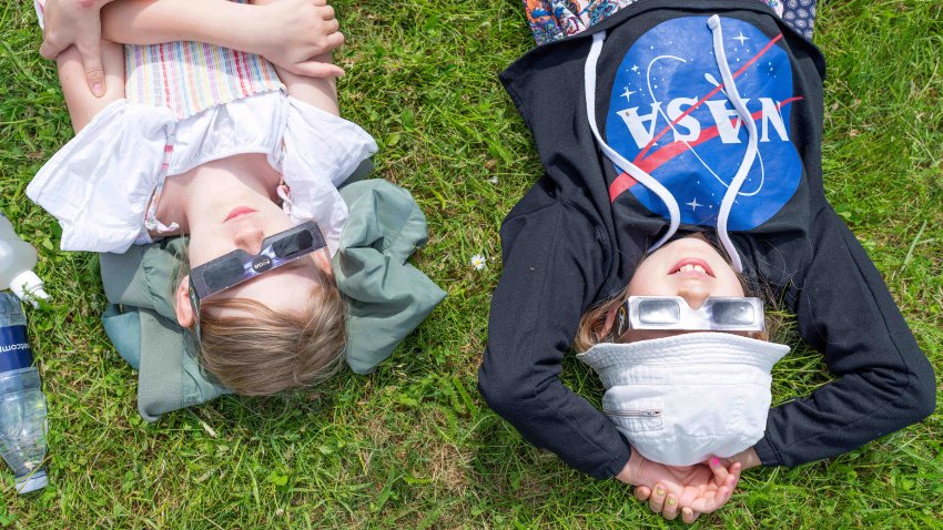 Children lie on the lawn and look through glasses waiting for the partial solar eclipse at the Brorfelde Observatory in Tollose, Denmark, on June 10, 2021. – A partial solar eclipse was visible over the Earth’s northern hemisphere with parts of Canada and Siberia privy to the best view of the celestial event. – Denmark OUT (Photo by Claus Bech / Ritzau Scanpix / AFP) / Denmark OUT (Photo by CLAUS BECH/Ritzau Scanpix/AFP via Getty Images)