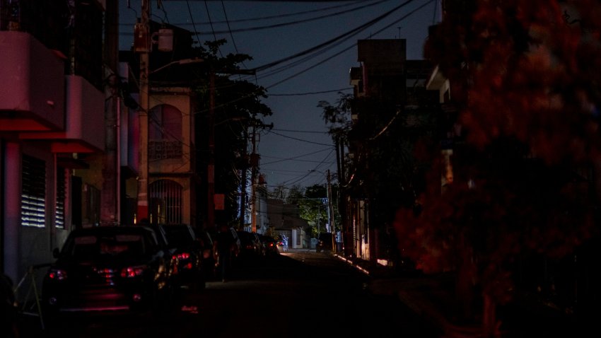 The headlights of a car are seen on an otherwise dark street in San Juan, Puerto Rico after a major power outage hit the island on April 6, 2022. (Photo by Ricardo ARDUENGO / AFP) (Photo by RICARDO ARDUENGO/AFP via Getty Images)