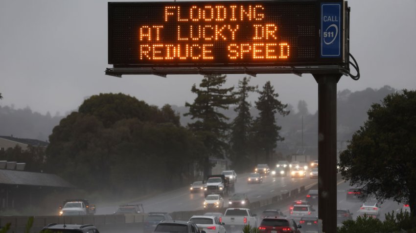 CORTE MADERA, CALIFORNIA – NOVEMBER 21: A sign warns drivers of flooding on Highway 101 on November 21, 2024, in Corte Madera, California. An atmospheric river is bringing heavy rains and wind to the San Francisco Bay Area for a second day and is expected to rain through the weekend. (Photo by Justin Sullivan/Getty Images)