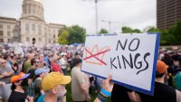 A demonstrator holds a sign during a "No Kings" protest