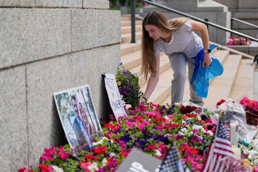 Claire Stein coloca flores en un monumento improvisado para la representante estatal de Minnesota, Melissa Hortman, y su esposo, Mark, en el Capitolio estatal, el domingo 15 de junio de 2025, en St. Paul, Minnesota. 